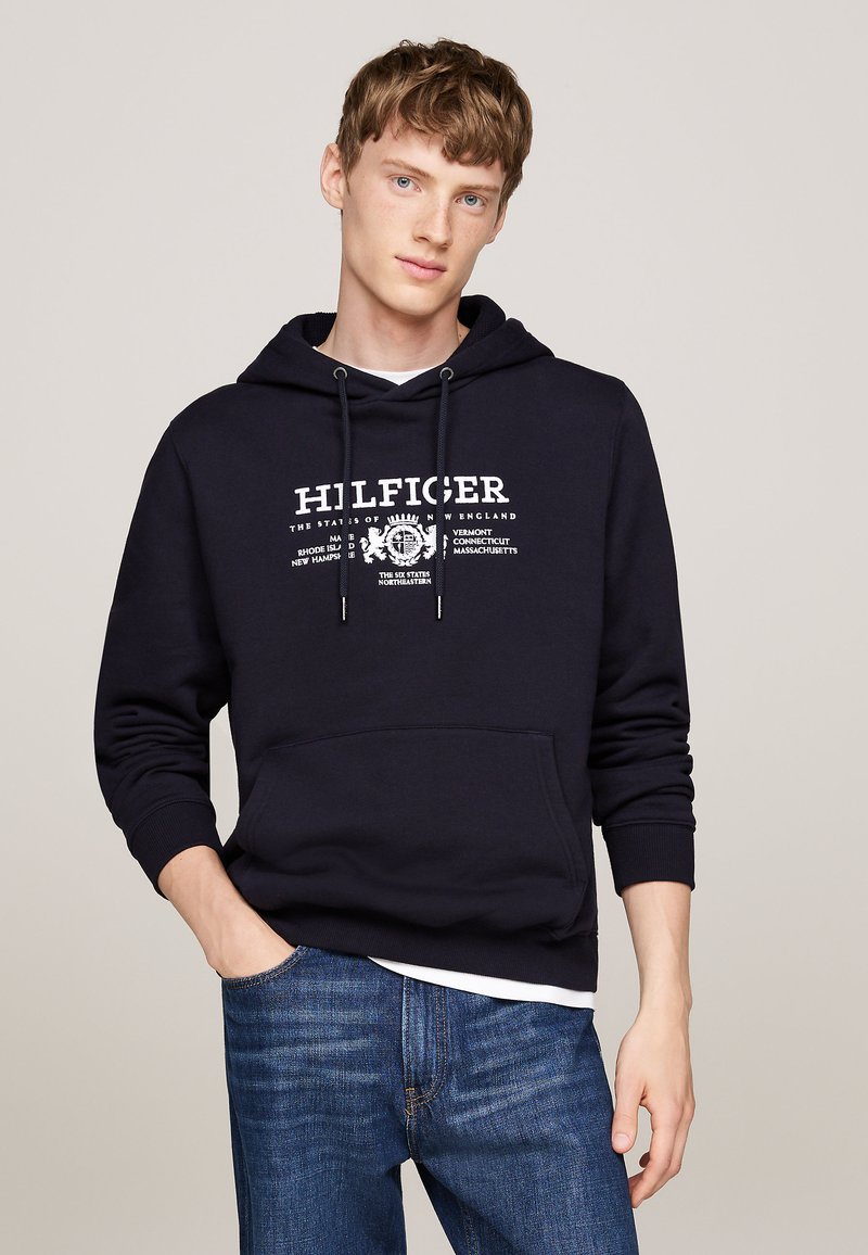 Sudadera azul marino de algodón con capucha ajustable y bolsillo frontal tipo canguro. Presenta texto blanco y un diseño gráfico en el pecho.