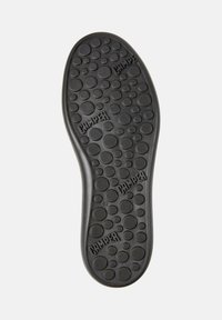 Sole of black Camper shoe with circular tread pattern and camper logos embossed, size 42 marked near the heel.