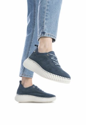 Zapatillas de ante azul con diseño perforado y suela blanca con estrías. Presentan cordones redondos y una pestaña en el talón para facilitar su calzado.