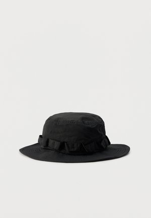 Schwarzer breitkrempiger Bucket-Hut mit einem gerafften Stoffband um die Krone, dargestellt vor einem schlichten hellen Hintergrund.