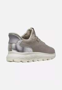 Basket gris en maille et cuir avec lacets à l'avant et semelle blanche épaisse aux motifs ondulés, vue de l'arrière côté.