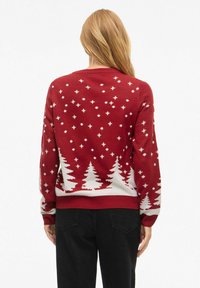 Punane kudumine särk valgete puu ja tähe motiividega, soonikkoes varrukate ja hemiga, ümmargune kaelus ning pehme tekstuur.