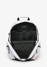 Sac à dos noir et blanc avec une ouverture zippée, comprenant un grand compartiment, des poches intérieures et une section en maille pour le rangement.