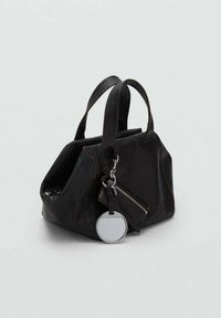 Borsa a tracolla in pelle nera con due manici, pochette con zip attaccata e portachiavi rotondo in argento su sfondo grigio chiaro.