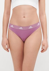 Fialové bavlněné tangá s hladkým povrchem, se širokým elastickým pasem zdobeným bílými logy Adidas.