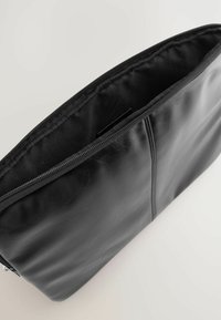 Must have nahkakott tekstuuriga pinnaga ja lukuga. Sisepind on kaetud musta kangaga, näidates lihtsat ja funktsionaalset disaini.