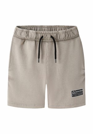 Short beige à taille élastique avec cordon noir et poches latérales, avec un patch « SUM:MER AT THE COAST » sur la jambe gauche.