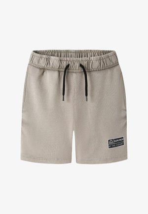 Short beige à taille élastique avec cordon noir et poches latérales, avec un patch « SUM:MER AT THE COAST » sur la jambe gauche.