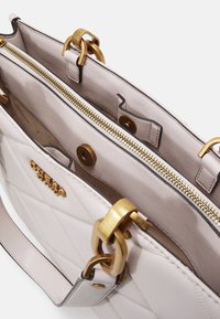 Borsa a tracolla beige trapuntata con hardware dorato, dotata di un compartimento con zip e tasche interne, design strutturato con manici robusti.