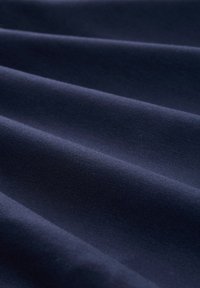 Mörknavy tyg med en jämn textur, som har subtila vågor och ett enhetligt vävmönster. Inga synliga dekorationer eller hårdvara.