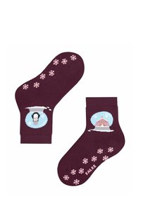 Burgunderfarbene Socken mit rosa Schneeflockenmuster und Motiven eines Pinguins in einer Schneekugel sowie eines Zirkuszeltes vor einem hellblauen Hintergrund.