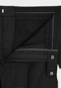 Sorte bukser med lynlåsgylf. Har en glat tekstur, forstærkede sømme og indvendige lommer med gråt trim og metaldetaljer.