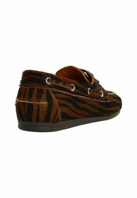 Braun und schwarz gestreifte Slipper aus Fell, mit Metallösen und einer flachen Gummisohle. Das orangefarbene Innenfutter ist sichtbar.