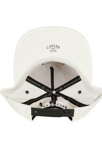 White snapback cap featuring a black logo "CAYLER & SONS" inside, with black and white patterned lining and adjustable plastic strap.
