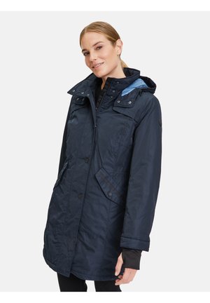 Navyblaue wasserdichte Jacke mit abnehmbarem Kapuzen, Reißverschluss und Druckknopfverschluss sowie mehreren Taschen. Texturierter Stoff und kontrastierende Fütterung.