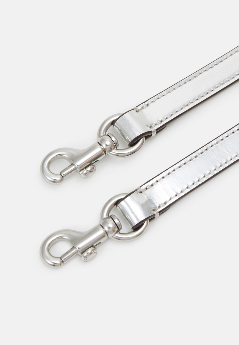 Sangle en simili cuir argenté avec quincaillerie métallique, comportant deux fermoirs à ressort en métal et une texture lisse et brillante.