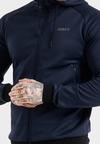 Marineblauwe hooded sweatshirt van gladde stof; voorzien van een volle rits, zwarte afwerking aan de boorden en een klein logo op de borst.