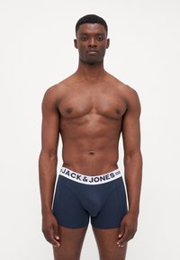 Navyblaue Boxer Shorts mit weißem Bund und "JACK & JONES"-Logo. Glattes Material, eng anliegendes Design und kurze Beinschneider.
