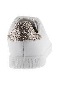 Sneaker bianco con suola texturizzata bianca, caratterizzato da un accento dorato scintillante sul tallone e una parte superiore in similpelle liscia.