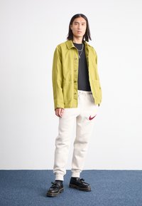 Nike Sportswear JOGGER - Παντελόνι φόρμας - light orewood brown