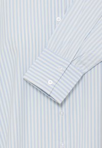 Világoskék és fehér csíkos ing, gombos kialakítással, egysoros gombos mandzsettával és sima anyagstruktúrával, szabott fazonban.