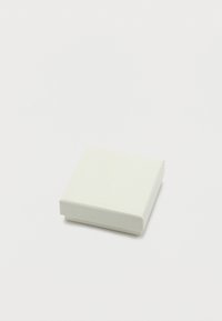 Μικρό κλειστό λευκό διακοσμημένο κουτί κοσμημάτων σε απλό λευκό φόντο, από γωνία πάνω.