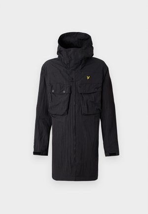 Svart huva parka med framsida dragkedja, två knäppta bröstfickor och en liten gul örnlogotyp på vänster bröst.