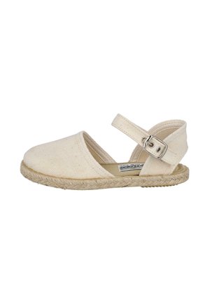 Sandalia espadrille de lona beige con puntera cerrada, correa en el tobillo con hebilla metálica y suela trenzada de yute sobre fondo blanco.