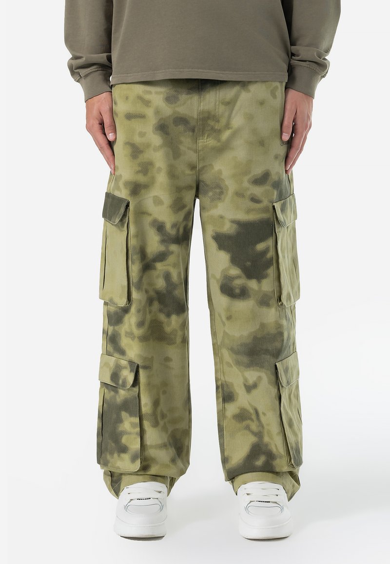 Pantalones cargo con un patrón de camuflaje, que presentan grandes bolsillos laterales, hechos de una tela texturizada y duradera en tonos de verde oliva.