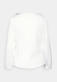 Weiße Bluse mit langen Ärmeln, glatter Textur, runder Ausschnitt und dezenten Falten im Rücken. Mit gerafften Ärmeln und Knopfmanschetten.