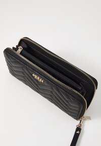 Portafoglio in pelle trapuntata nera con zip e accessori in tonalità oro, dotato di doppio scomparto e tracolla per un trasporto sicuro.