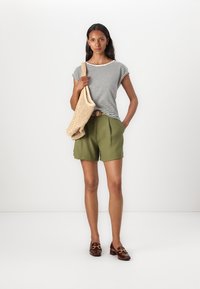 Haut à rayures à manches courtes, shorts olive, sac tissé et mocassins marron. Détails notables : tissu léger, coupe décontractée et ceinture classique.