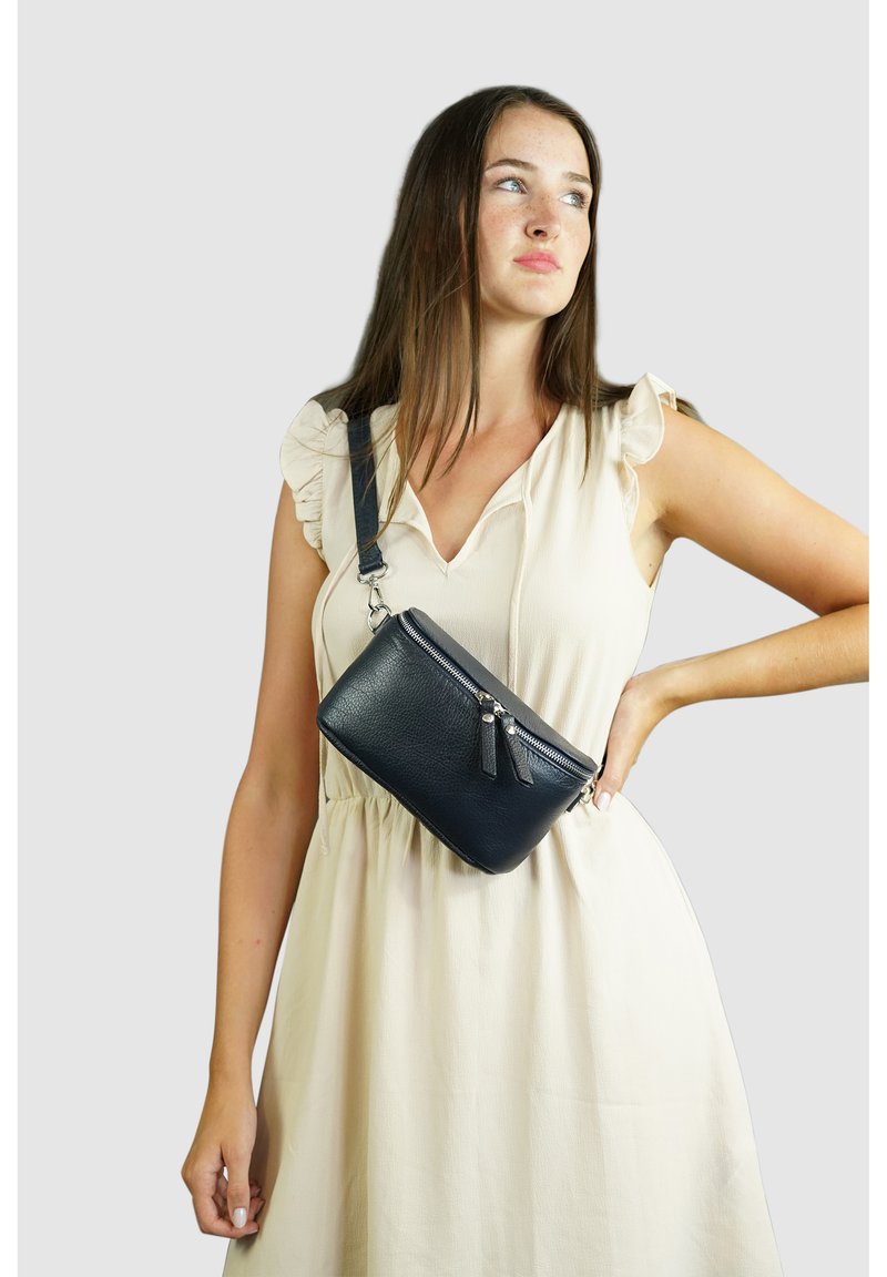 Navy Leder Umhängetasche mit strukturiertem Finish, Reißverschluss und dekorativen Quasten. Verstellbarer Träger. Kompakte rechteckige Form.