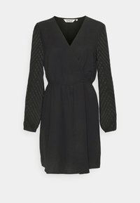 Robe noire à manches longues avec col en V, taille élastique et manches transparentes texturées en motif chevron.