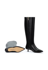 Botas negras hasta la rodilla de cuero suave, con punta afilada y un pequeño tacón de gato. Cierre de cremallera en la parte posterior y plantillas de marca visibles.
