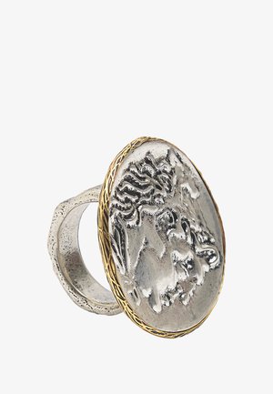 Srebrny pierścionek z wyrazistym okrągłym medalionem z motywem lwa, zdobiony złotym plecionym brzegiem i fakturowaną obrączką.