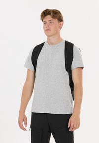 Harmaa lyhythihainen T-paita, joka on valmistettu puuvillasekoitteesta, yhdistetty mustaan kangaskassiin. Paidassa on pyöreä kaula-aukko ja rento istuvuus.