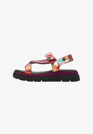 Colorful sandal featuring a black rubber sole, two patterned straps in pink, orange, and blue, and a cushioned purple midsole for comfort.