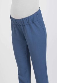 Blue elastic waistband pants made of soft fabric, featuring side pockets and a straight-leg design. Smooth texture and minimal seams.