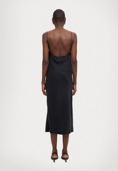 Black, sleeveless dress with a low back and a straight silhouette. Made of smooth fabric, featuring a mid-calf length and subtle sheen.