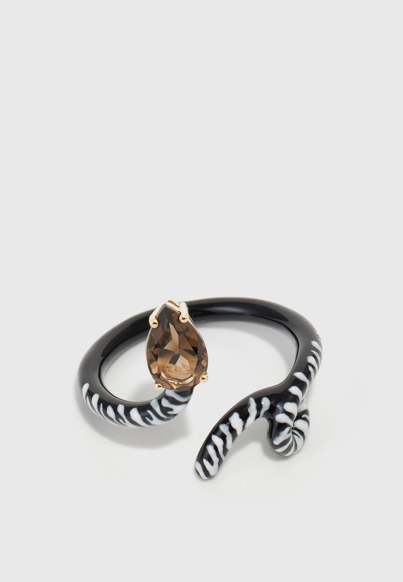 Fekete gyűrű, körte alakú barna drágakővel. Csavart mintázata van, fehér csíkokkal, amelyek kontrasztot teremtenek a textúrában és a mintázatban.