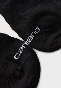 Schwarze Knöchelsocken mit einer weichen Textur, einem figurbetonten Design und weißem gesticktem "carnano"-Logo an der Außenseite.
