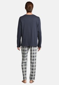 Marinblus med lång ärm och rund halsringning, i kombination med ljusa rutiga pyjamasbyxor. Mjuk, lätt tyg med avslappnad passform.