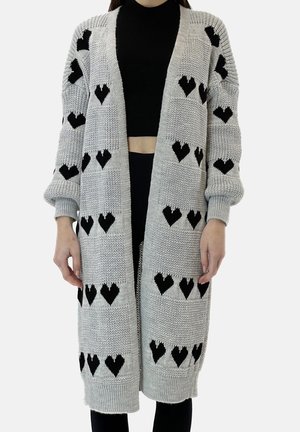 Szary dzianinowy kardigan z czarnymi wzorami serc, odkryty przód, długie rękawy i luźny krój. Teksturowana tkanina zapewnia ciepło.