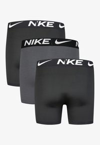 Dreierpack Herren Nike Boxer Shorts in Schwarz und Grau. Weicher Stoff, elastischer Bund mit weißem "Nike"-Logo, enganliegendes Design.