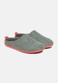 Grå hjemmesko i et slip-on design, med røde accenter på kanterne og sålerne. Enkel form, blød struktur og minimal detaljering.