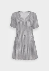 Vestido xadrez preto e branco com mangas curtas, decote em V, fecho frontal com botões e um único bolso no peito. Tecido suave e silhueta evasé.
