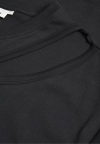 Sort bomulds T-shirt med rund halsudskæring, glat tekstur og dobbeltlag design på den øverste front for ekstra detalje.