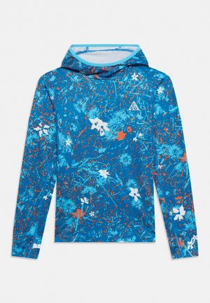 Haut à capuche bleu à manches longues avec imprimé floral abstrait et éclaboussures en bleu clair, blanc et orange, avec un petit logo triangulaire sur la poitrine.