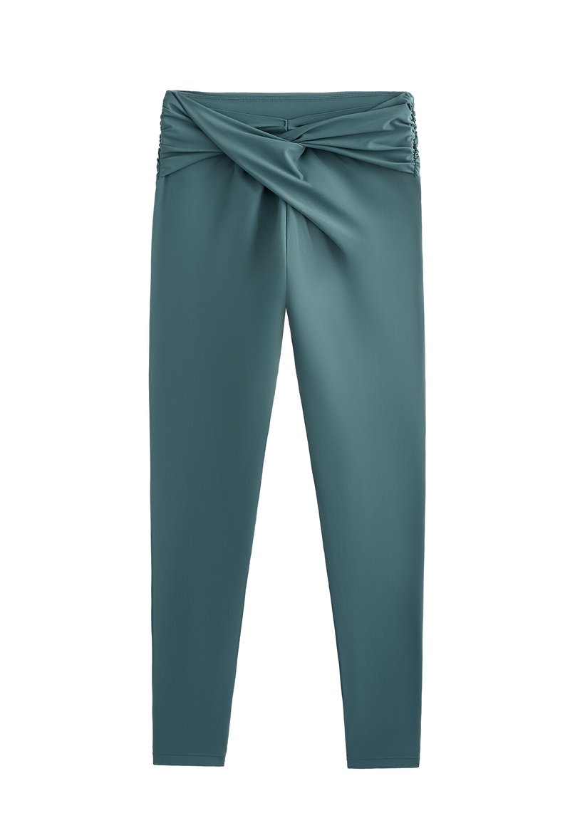 Tirkizne tajice s nabaravanjem i zavrnutim dizajnom pojasa. Izrađene od glatkog, rastezljivog materijala. Elegantna, prilagodljiva silueta.